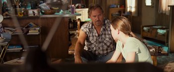 Movie still from “Swing Vote” (2008), directed by Joshua Michael Stern – A man and a woman sitting on the floor in front of a tv; Medium shot, Over the shoulder angle