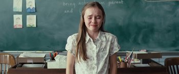 Movie still from “Swing Vote” (2008), directed by Joshua Michael Stern – A young girl in front of a chalkboard crying; Medium shot, High angle