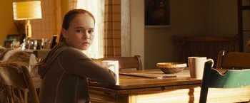 Movie still from “Swing Vote” (2008), directed by Joshua Michael Stern – A girl sitting at a table with a cup of coffee; Close Up shot, Over the shoulder angle