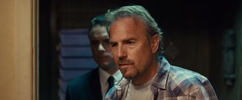 Movie still from “Swing Vote” (2008), directed by Joshua Michael Stern – A man in a plaid shirt and a man in a black suit; Close Up shot, Over the shoulder angle