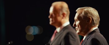 Movie still from “Swing Vote” (2008), directed by Joshua Michael Stern – Two men in business suits standing next to each other; Close Up shot, Low angle