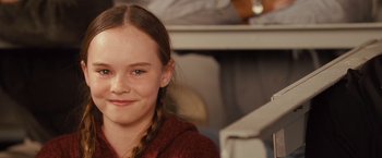 Movie still from “Swing Vote” (2008), directed by Joshua Michael Stern – A young girl is smiling for the camera; Close Up shot, Over the shoulder angle
