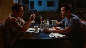 Movie still from “Swingers” (1996), directed by Doug Liman – Two men sitting at a table with plates of pizza; Medium shot, High angle