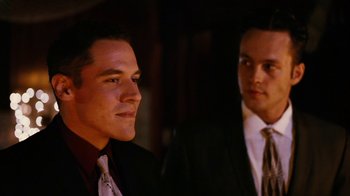 Movie still from “Swingers” (1996), directed by Doug Liman – Two young men in suits and ties are posing for a picture; Close Up shot, Over the shoulder angle