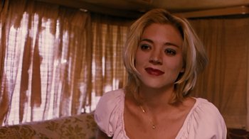 Movie still from “Swingers” (1996), directed by Doug Liman – A woman with blonde hair is smiling for the camera; Close Up shot, Over the shoulder angle