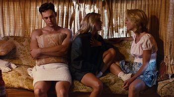 Movie still from “Swingers” (1996), directed by Doug Liman – Two women and a man sitting on a couch; Medium shot, Over the shoulder angle