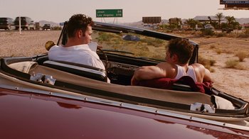 Movie still from “Swingers” (1996), directed by Doug Liman – Two young men in a red convertible driving down a road; Medium shot, Over the shoulder angle