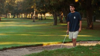 Movie still from “Swingers” (1996), directed by Doug Liman – A man standing on a golf course holding a golf club; Wide shot, Low angle