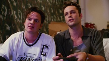 Movie still from “Swingers” (1996), directed by Doug Liman – Two young men sitting next to each other holding remotes; Close Up shot, High angle