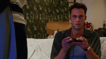 Movie still from “Swingers” (1996), directed by Doug Liman – A man sitting on a bed playing a video game; Close Up shot, High angle