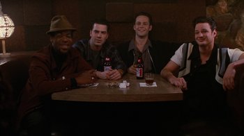 Movie still from “Swingers” (1996), directed by Doug Liman – A group of men sitting at a table with drinks; Medium shot, High angle