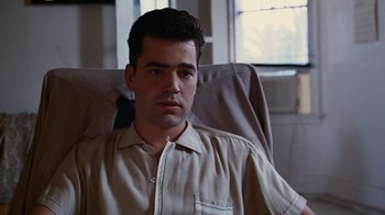 Movie still from “Swingers” (1996), directed by Doug Liman – A man sitting in a chair looking at the camera; Close Up shot, Low angle