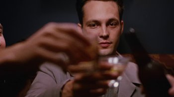 Movie still from “Swingers” (1996), directed by Doug Liman – A man holding a glass in his hand; Close Up shot, Overhead angle