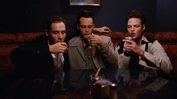 Movie still from “Swingers” (1996), directed by Doug Liman – A group of men sitting at a table drinking wine; Medium shot, High angle