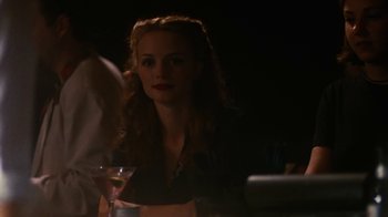 Movie still from “Swingers” (1996), directed by Doug Liman – A woman sitting at a table with a glass of wine in front of her; Close Up shot, Over the shoulder angle