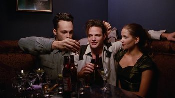 Movie still from “Swingers” (1996), directed by Doug Liman – A group of people sitting at a table with drinks; Medium shot, High angle
