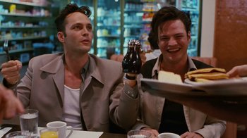 Movie still from “Swingers” (1996), directed by Doug Liman – A couple of men sitting at a table with food; Medium shot, Low angle