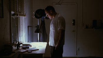 Movie still from “Swingers” (1996), directed by Doug Liman – A man standing next to a table in a room; Medium shot, Low angle