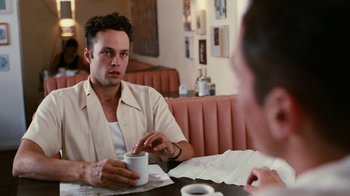 Movie still from “Swingers” (1996), directed by Doug Liman – A man sitting in front of another man holding a coffee cup; Close Up shot, Over the shoulder angle
