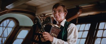 Movie still from “Swiss Family Robinson” (1960), directed by Ken Annakin – A young man holding a large pot in his hands; Close Up shot, Low angle
