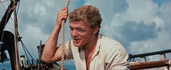 Movie still from “Swiss Family Robinson” (1960), directed by Ken Annakin – A man holding on to a rope while sitting on a boat; Close Up shot, High angle