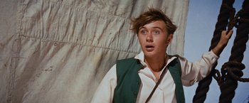 Movie still from “Swiss Family Robinson” (1960), directed by Ken Annakin – A young man in a white shirt and a green vest; Close Up shot, Low angle