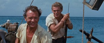 Movie still from “Swiss Family Robinson” (1960), directed by Ken Annakin – Two men are standing on a boat in the water; Medium shot, Low angle