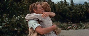Movie still from “Swiss Family Robinson” (1960), directed by Ken Annakin – A man and a woman hugging each other in a field; Medium shot, Over the shoulder angle