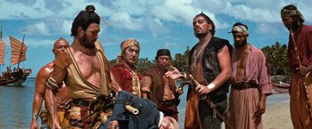 Movie still from “Swiss Family Robinson” (1960), directed by Ken Annakin – A group of men standing next to a body of water; Medium shot, Low angle