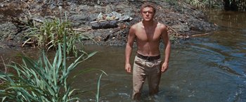 Movie still from “Swiss Family Robinson” (1960), directed by Ken Annakin – A man standing in the water in a river; Medium shot, Low angle