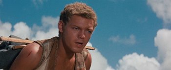 Movie still from “Swiss Family Robinson” (1960), directed by Ken Annakin – A person holding a stick in his mouth; Close Up shot, Low angle