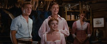 Movie still from “Swiss Family Robinson” (1960), directed by Ken Annakin – A man and a woman standing next to each other in a room; Medium shot, Low angle