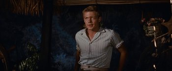 Movie still from “Swiss Family Robinson” (1960), directed by Ken Annakin – A man in a striped shirt standing in front of a wall; Medium shot, Over the shoulder angle