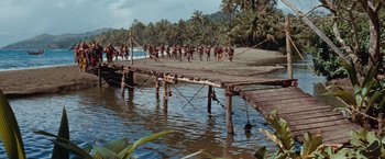 Movie still from “Swiss Family Robinson” (1960), directed by Ken Annakin – A group of people running across a bridge; Extreme Wide shot, High angle