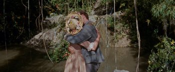 Movie still from “Swiss Family Robinson” (1960), directed by Ken Annakin – A man and a woman hugging in front of a waterfall; Medium shot, High angle