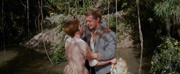 Movie still from “Swiss Family Robinson” (1960), directed by Ken Annakin – A man and a woman dancing in front of trees; Medium shot, High angle