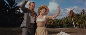 Movie still from “Swiss Family Robinson” (1960), directed by Ken Annakin – A man and a woman wave at the camera; Medium shot, Low angle