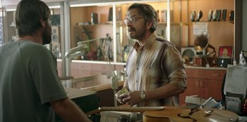 Movie still from “Sword of Trust” (2019), directed by Lynn Shelton – A man with a beard is playing a guitar; Medium shot, Over the shoulder angle