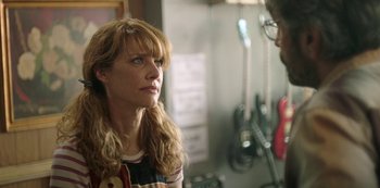 Movie still from “Sword of Trust” (2019), directed by Lynn Shelton – A woman standing next to a man in front of a guitar; Close Up shot, Over the shoulder angle