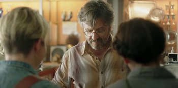 Movie still from “Sword of Trust” (2019), directed by Lynn Shelton – An older man wearing glasses looking at a woman; Close Up shot, Over the shoulder angle