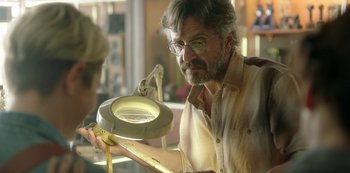 Movie still from “Sword of Trust” (2019), directed by Lynn Shelton – A man looking at something in a magnifying glass; Close Up shot, Over the shoulder angle