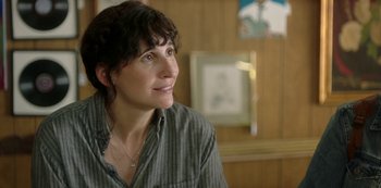 Movie still from “Sword of Trust” (2019), directed by Lynn Shelton – A woman in a striped shirt is looking up; Close Up shot, Over the shoulder angle