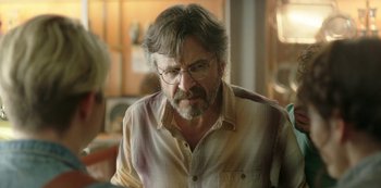 Movie still from “Sword of Trust” (2019), directed by Lynn Shelton – An older man wearing glasses and a plaid shirt; Close Up shot, Over the shoulder angle