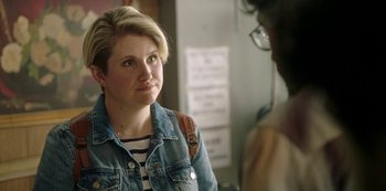 Movie still from “Sword of Trust” (2019), directed by Lynn Shelton – A woman in a jean jacket talking to another person; Close Up shot, Over the shoulder angle