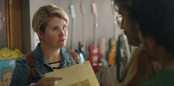 Movie still from “Sword of Trust” (2019), directed by Lynn Shelton – A woman holding a piece of paper talking to another person; Close Up shot, Over the shoulder angle
