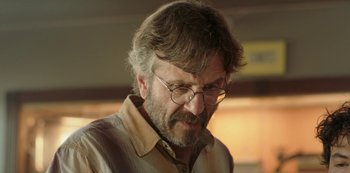 Movie still from “Sword of Trust” (2019), directed by Lynn Shelton – An older man wearing glasses and a tan shirt; Close Up shot, Over the shoulder angle
