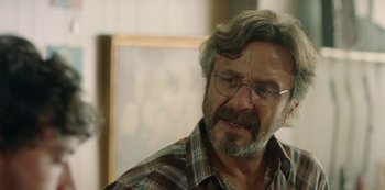 Movie still from “Sword of Trust” (2019), directed by Lynn Shelton – An older man wearing glasses and a plaid shirt; Close Up shot, Over the shoulder angle