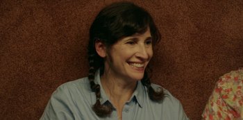 Movie still from “Sword of Trust” (2019), directed by Lynn Shelton – A woman with two pigtails sitting in front of a brown wall; Close Up shot, High angle