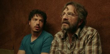 Movie still from “Sword of Trust” (2019), directed by Lynn Shelton – Two men sitting next to each other on a brown wall; Close Up shot, Over the shoulder angle