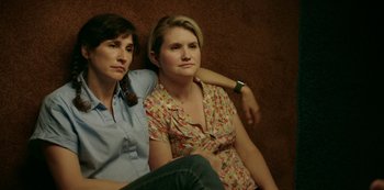 Movie still from “Sword of Trust” (2019), directed by Lynn Shelton – A couple of women sitting next to each other on a couch; Close Up shot, High angle